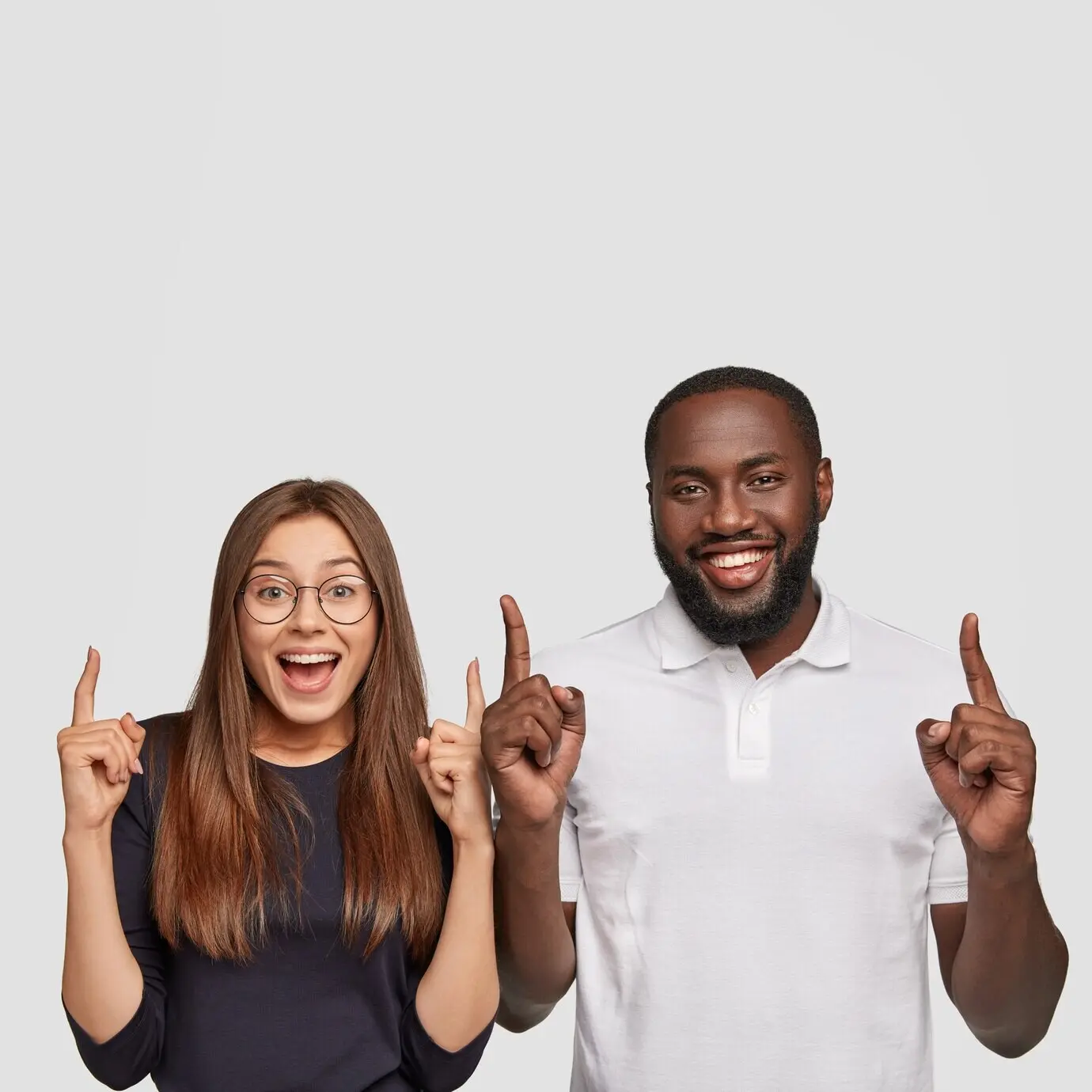 Upbeat interracial friends heading to grab a snack at the cafeteria, showing where they’re going by pointing upward with their index fingers.